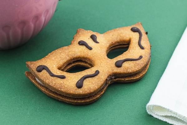 Biscotto mascherina di carnevale ripieno di crema alla nocciola