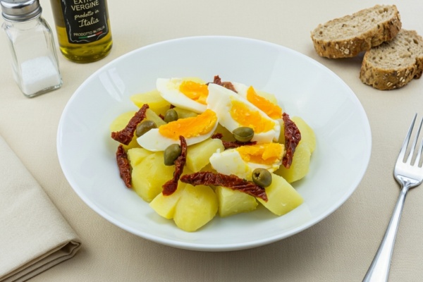 Insalata di patate con uovo, olive e pomodori secchi